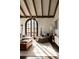 Sun-drenched living room boasts exposed beams, textured walls, large arched door, and comfortable furnishings at 3 Carriage Brook Rd, Cherry Hills Village, CO 80121