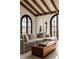 Cozy living room with exposed wood beams, arched doorways, and a comfortable sectional sofa at 3 Carriage Brook Rd, Cherry Hills Village, CO 80121