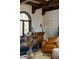 Cozy seating area with a rustic bar, leather armchair, and natural light from arched window at 3 Carriage Brook Rd, Cherry Hills Village, CO 80121