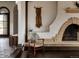 Unique living room with a brick fireplace, archways, wood accents, and interesting wall texture at 3 Carriage Brook Rd, Cherry Hills Village, CO 80121