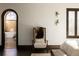 Charming main bedroom with accent chair, textured walls, and arched doorway to tiled bathroom at 3 Carriage Brook Rd, Cherry Hills Village, CO 80121