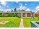Large backyard with covered patio, mature trees, and lush green lawn at 3049 S Williams St, Denver, CO 80210