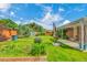 Spacious backyard with a covered patio, well-maintained lawn, and colorful flowers at 3049 S Williams St, Denver, CO 80210