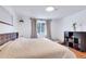 Bright bedroom features hardwood floors and a large window with views of foliage at 3049 S Williams St, Denver, CO 80210