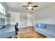 Bright bedroom featuring hardwood floors, a ceiling fan, and a stylish grey couch at 3049 S Williams St, Denver, CO 80210