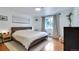 Bright bedroom features hardwood floors and a large window with natural light at 3049 S Williams St, Denver, CO 80210