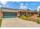 Home's exterior with a two-car garage, a well-manicured lawn, and a brick facade at 3049 S Williams St, Denver, CO 80210