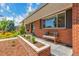 Charming front porch featuring a brick facade, garden bed, and cozy bench seating at 3049 S Williams St, Denver, CO 80210