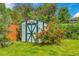 Backyard shed surrounded by lush greenery and a vibrant blooming rose bush at 3049 S Williams St, Denver, CO 80210