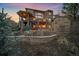 Stunning back exterior featuring a stone fireplace, patio, spiral staircase, and well-manicured landscaping at 1159 Buffalo Ridge Rd, Castle Pines, CO 80108