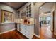 Elegant bar area with custom cabinets, a wine rack, and a view into the adjacent dining area at 1159 Buffalo Ridge Rd, Castle Pines, CO 80108