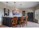 Basement bar area with granite countertop, stylish chairs, and modern decor at 1159 Buffalo Ridge Rd, Castle Pines, CO 80108