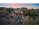 A beautiful home surrounded by lush trees and landscaping at dusk at 1159 Buffalo Ridge Rd, Castle Pines, CO 80108