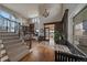 Bright, inviting foyer features hardwood floors, a staircase, and seamless access to the living room and dining area at 1159 Buffalo Ridge Rd, Castle Pines, CO 80108