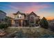 Beautiful home featuring stone accents, lush landscaping, and a well-manicured lawn, creating stunning curb appeal at 1159 Buffalo Ridge Rd, Castle Pines, CO 80108