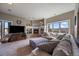 Cozy living room features a stone fireplace, large windows, and comfortable seating at 1159 Buffalo Ridge Rd, Castle Pines, CO 80108