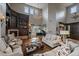Bright living room featuring a fireplace, grand piano, and a statement chandelier at 1159 Buffalo Ridge Rd, Castle Pines, CO 80108