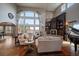 Bright living room featuring hardwood floors, a fireplace with built-ins, large windows, and a striking chandelier at 1159 Buffalo Ridge Rd, Castle Pines, CO 80108