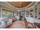 Cozy room features a ceiling light, an accent rug, large windows, and custom built-in bookshelves with cabinets at 1159 Buffalo Ridge Rd, Castle Pines, CO 80108