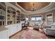 Stylish home office featuring custom built-in shelving, a desk, comfortable seating, and lots of natural light at 1159 Buffalo Ridge Rd, Castle Pines, CO 80108