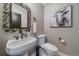 Powder room with a pedestal sink, decorative mirror, and artwork at 1159 Buffalo Ridge Rd, Castle Pines, CO 80108