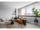 Studio apartment living room with a mustard-colored couch and large windows at 1196 N Grant St # 204, Denver, CO 80203