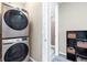 Well-equipped laundry area featuring stacked washer and dryer, storage shelves and an open shower at 23584 E 5Th Pl, Aurora, CO 80018