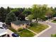 Aerial view of a brick home with a green roof, mature trees, and well-maintained lawns at 2592 S Winona Ct, Denver, CO 80219