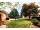Lush backyard with a brick patio, mature trees, and green grass, creating a serene outdoor space at 2592 S Winona Ct, Denver, CO 80219