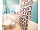 Cozy bathroom with patterned shower curtain and tiled flooring at 2592 S Winona Ct, Denver, CO 80219