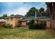 Charming brick home featuring mature trees, green lawn, and a cozy front porch at 2592 S Winona Ct, Denver, CO 80219