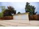 Two-car garage with painted doors and a concrete driveway, surrounded by a wooden fence at 2592 S Winona Ct, Denver, CO 80219