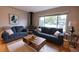 Cozy living room featuring wood floors, a vintage fireplace, and large windows at 2592 S Winona Ct, Denver, CO 80219