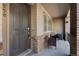 Inviting front porch with neutral siding, brick accents and comfortable seating area at 558 E Dry Creek Pl, Littleton, CO 80122