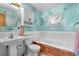 Charming bathroom with a pedestal sink, vintage decor, and a combined tub and shower at 11279 E Alaska Pl, Aurora, CO 80012
