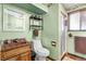 Vintage bathroom features a wooden vanity, toilet, and a tiled shower area at 11279 E Alaska Pl, Aurora, CO 80012