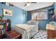 Bright bedroom featuring a cozy bed, a window view, and charming decor with wood trim at 11279 E Alaska Pl, Aurora, CO 80012