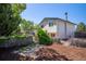 Rear exterior showcasing a two-story home with a lush yard and mature trees in a serene setting at 11279 E Alaska Pl, Aurora, CO 80012