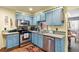 Cozy kitchen with stainless steel appliances, blue cabinets, and modern fixtures at 11279 E Alaska Pl, Aurora, CO 80012