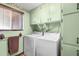 Efficient laundry room with a washer, dryer, storage cabinets, and a window for natural light at 11279 E Alaska Pl, Aurora, CO 80012