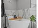 This bathroom showcases a modern soaking tub with a wood tray, complemented by stylish decor and marble-style tile at 425 Steele St, Denver, CO 80206