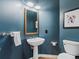 Stylish powder room boasts deep blue walls, pedestal sink, and unique decor at 425 Steele St, Denver, CO 80206