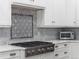 Close-up on a gas range and tile backsplash in bright, modern kitchen at 425 Steele St, Denver, CO 80206