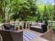Outdoor patio with wicker furniture, a blue and white rug and surrounding greenery at 425 Steele St, Denver, CO 80206