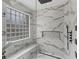 This modern shower features a glass enclosure, rainfall showerhead, and marble-style tile with a stylish niche at 425 Steele St, Denver, CO 80206