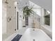 Bathroom featuring free standing tub, glass shower, and mosaic tile flooring at 1034 N Logan St # 2W, Denver, CO 80203