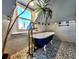 Bathroom featuring black clawfoot tub with unique fixtures and mosaic tile floor at 1034 N Logan St # 2W, Denver, CO 80203