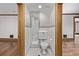 Compact powder room with a toilet and marble-tiled walls, framed by hardwood door frames at 1034 N Logan St # 2W, Denver, CO 80203