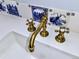 Close-up of white sink with unique bronze fixtures and decorative blue and white tiles at 1034 N Logan St # 2W, Denver, CO 80203