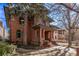 Charming exterior view of a brick home featuring mature trees, well-kept landscaping, and stone accents at 1034 N Logan St # 2W, Denver, CO 80203
